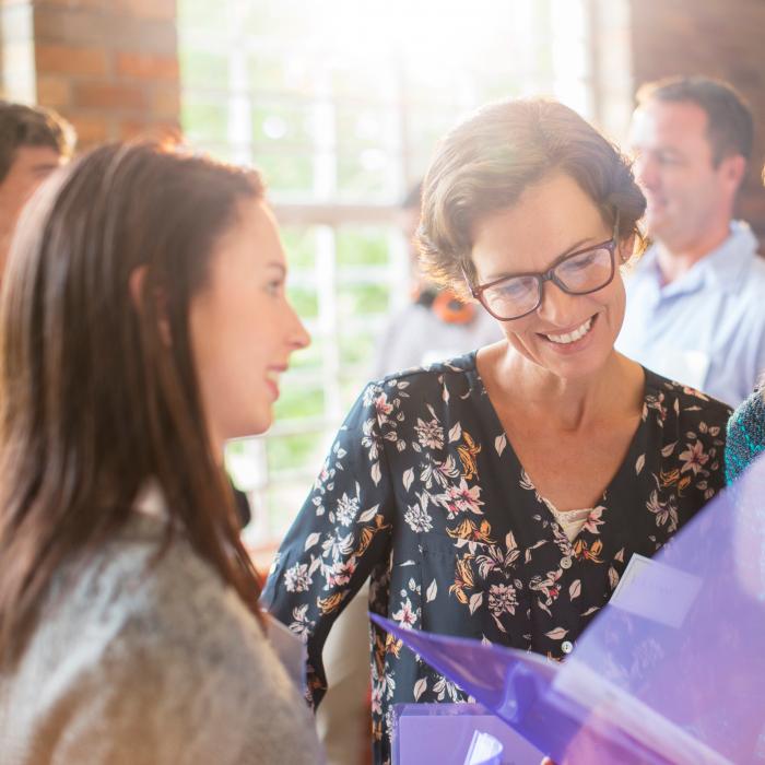 Three ladies of different ages looking at some documents 