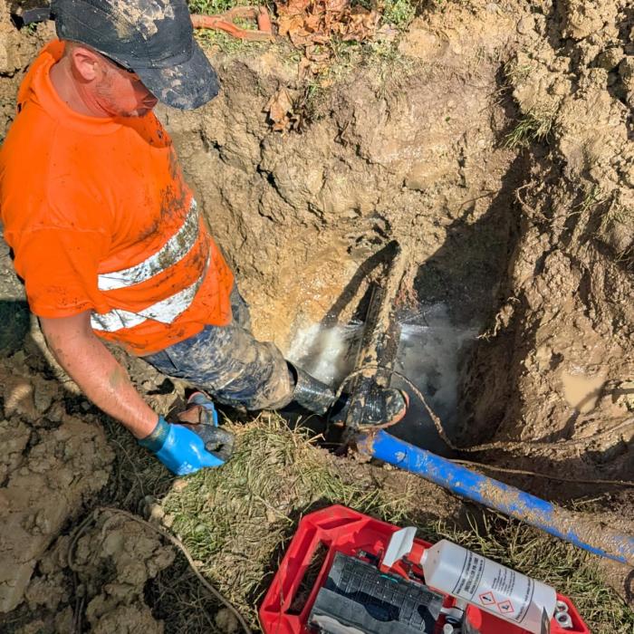 Maintenance worker fixing a burst water main