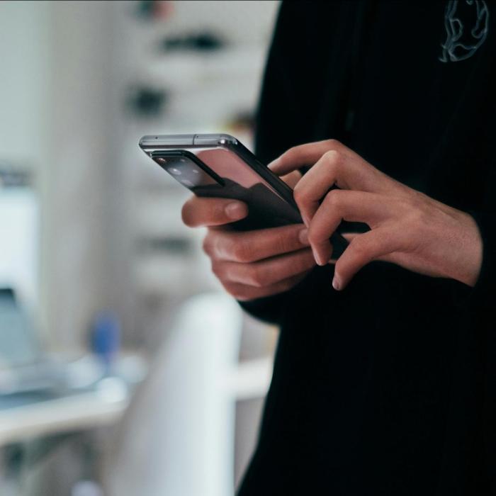 Person in black jumper using a smart phone